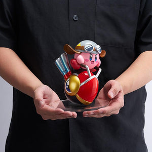 A person holding the 5.51-inch tall Pop Up Parade Kirby Wheelie Rider figure on its clear base, providing a real-world size and scale reference.