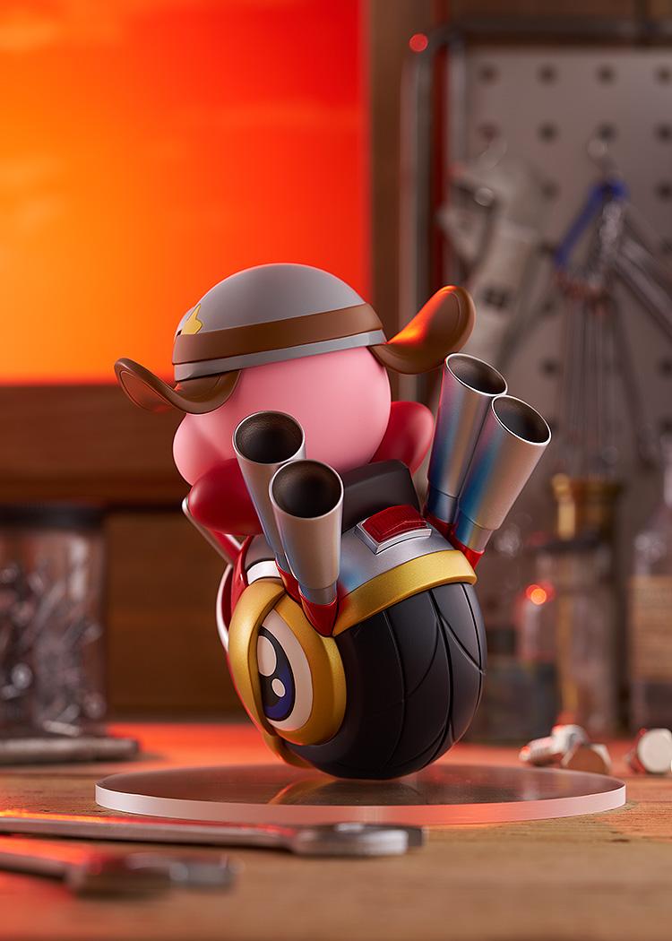 Back-right angle of the Kirby Wheelie Rider figure under warm lighting, detailing the dual metallic blue exhaust pipes and the textured black tire.
