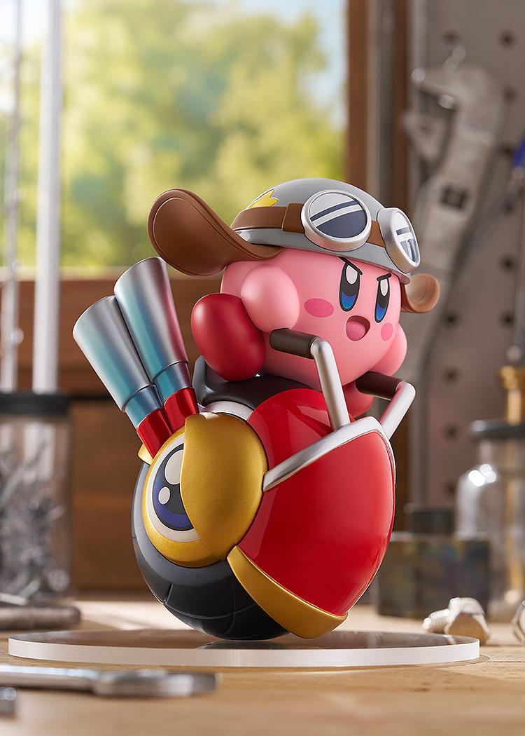 Close-up shot of the non-articulated Kirby Wheelie Rider figure in a workshop setting, focusing on his classic pink design, goggles, and the front wheel eye detail.