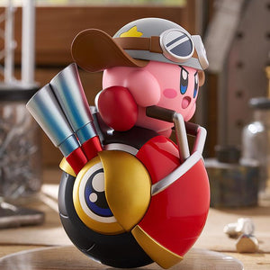 Right profile view of the Kirby Wheelie Rider figure in a workshop environment, highlighting the curved red body and gold side accents of the Wheelie vehicle.