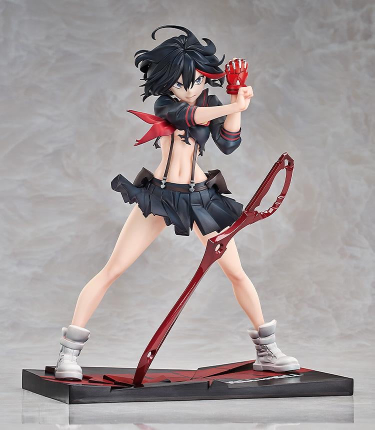 A full-body shot of the Ryuko Matoi figure in her uniform, with the red Scissor Blade resting on the battle-damaged base.