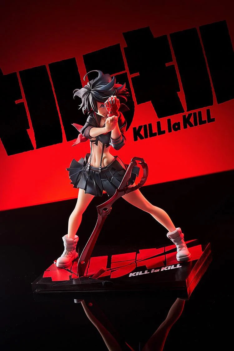 A low-angle shot of the Ryuko Matoi figure, emphasizing the intensity of her pose and the lighting against the red and black backdrop.