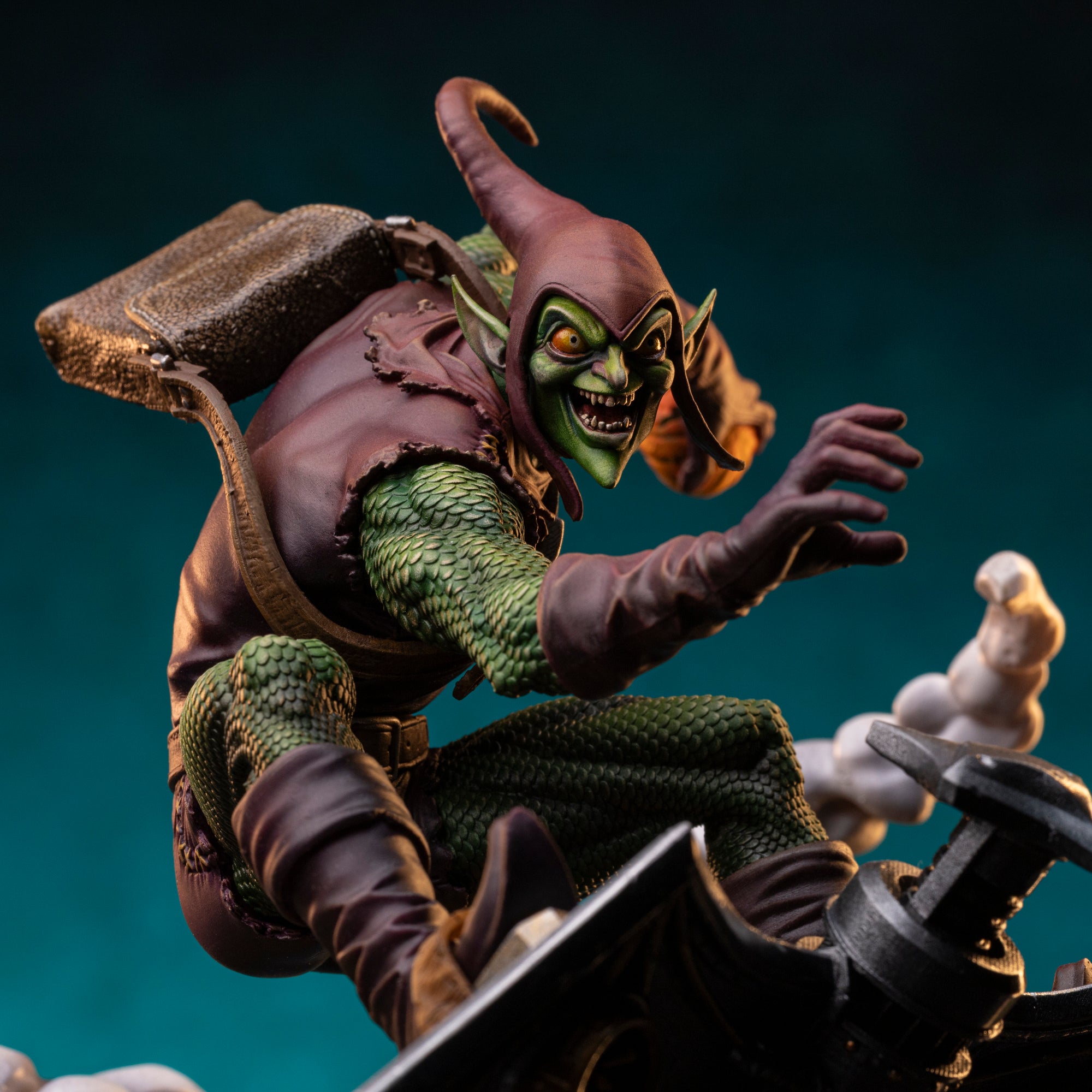 Close-up detail of Green Goblin statue face and pumpkin bomb, showing textured green skin and purple costume from the Iron Studios Spider-Man vs Sinister Six series.