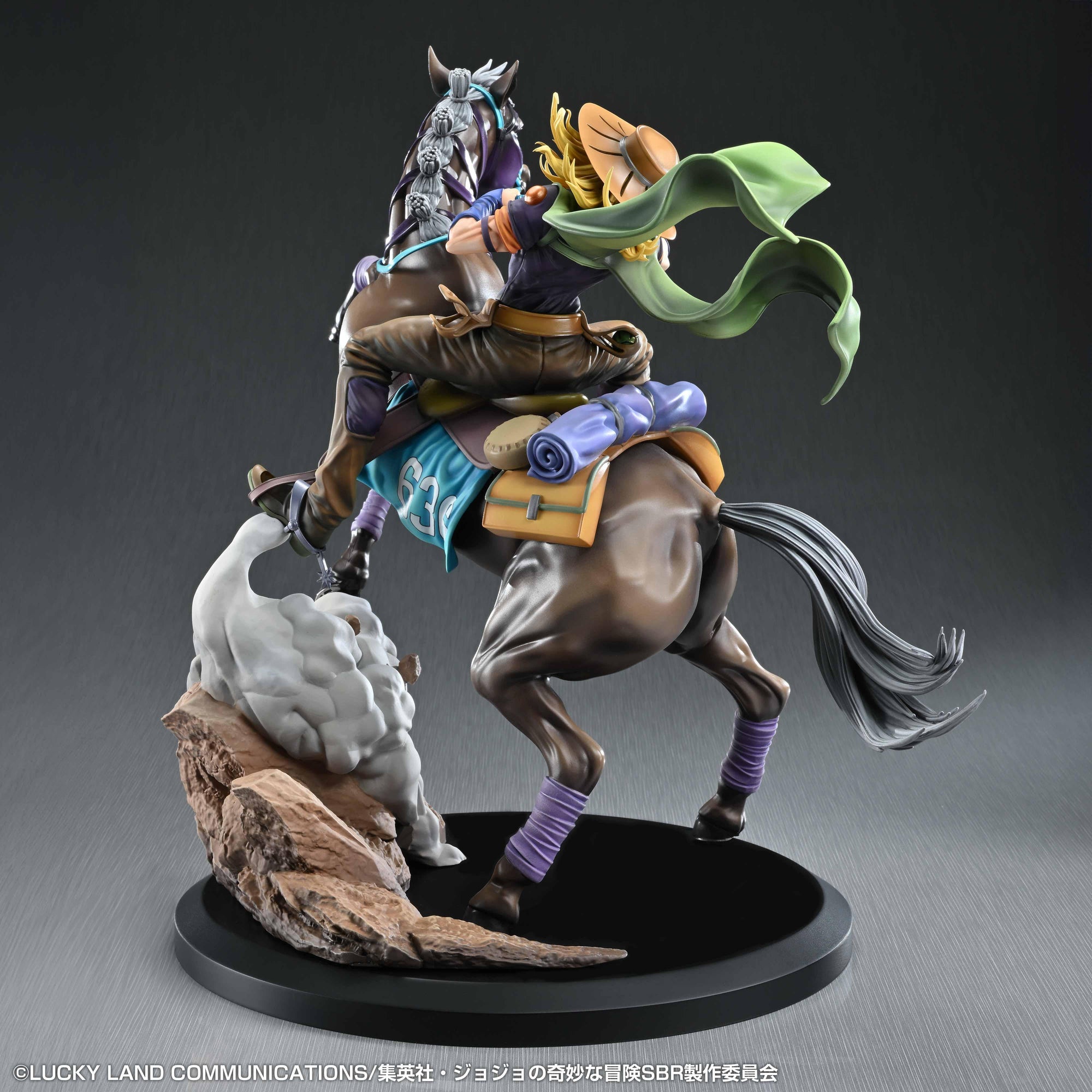 Rear left three-quarter view of the statue showing the turquoise saddle blanket featuring the race number 636, along with detailed stirrups and the rocky dust support base.