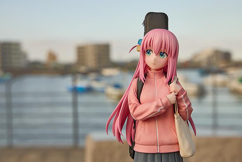 High-angle shot of the Hitori Gotoh figure standing outdoors with a blurred city and harbor background.
