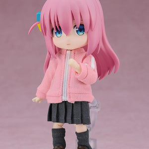 Full body front view of the highly articulated Hitori Gotoh Nendoroid Doll reissue figure standing on a clear plastic display base against a soft pink background.