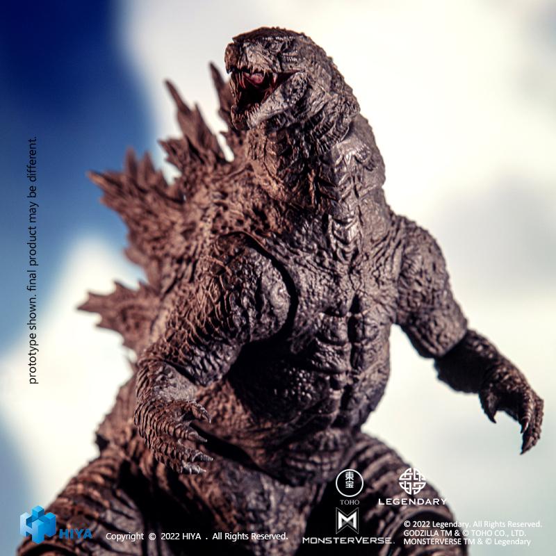 Low-angle close-up shot of HIYA Exquisite Basic Godzilla 2021 action figure set against a cloudy sky background.