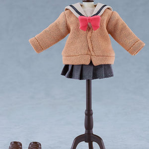 The brown fabric uniform sweater, pink bow, dark grey pleated skirt, and brown magnetic shoes of the Ikuyo Kita Nendoroid Doll displayed on a miniature black clothing stand.