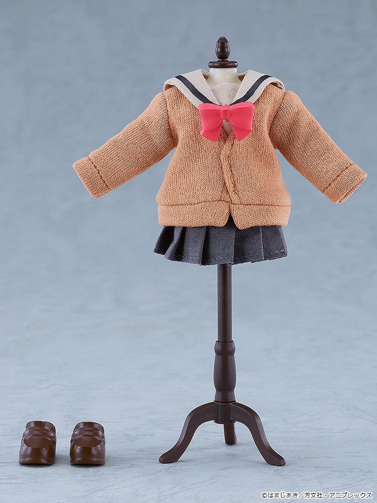 The brown fabric uniform sweater, pink bow, dark grey pleated skirt, and brown magnetic shoes of the Ikuyo Kita Nendoroid Doll displayed on a miniature black clothing stand.