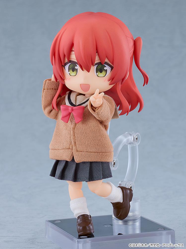 Articulated Ikuyo Kita Nendoroid Doll figure smiling while flashing a single peace sign, showcasing the high-quality fabric texture of her school sweater and pleated skirt.