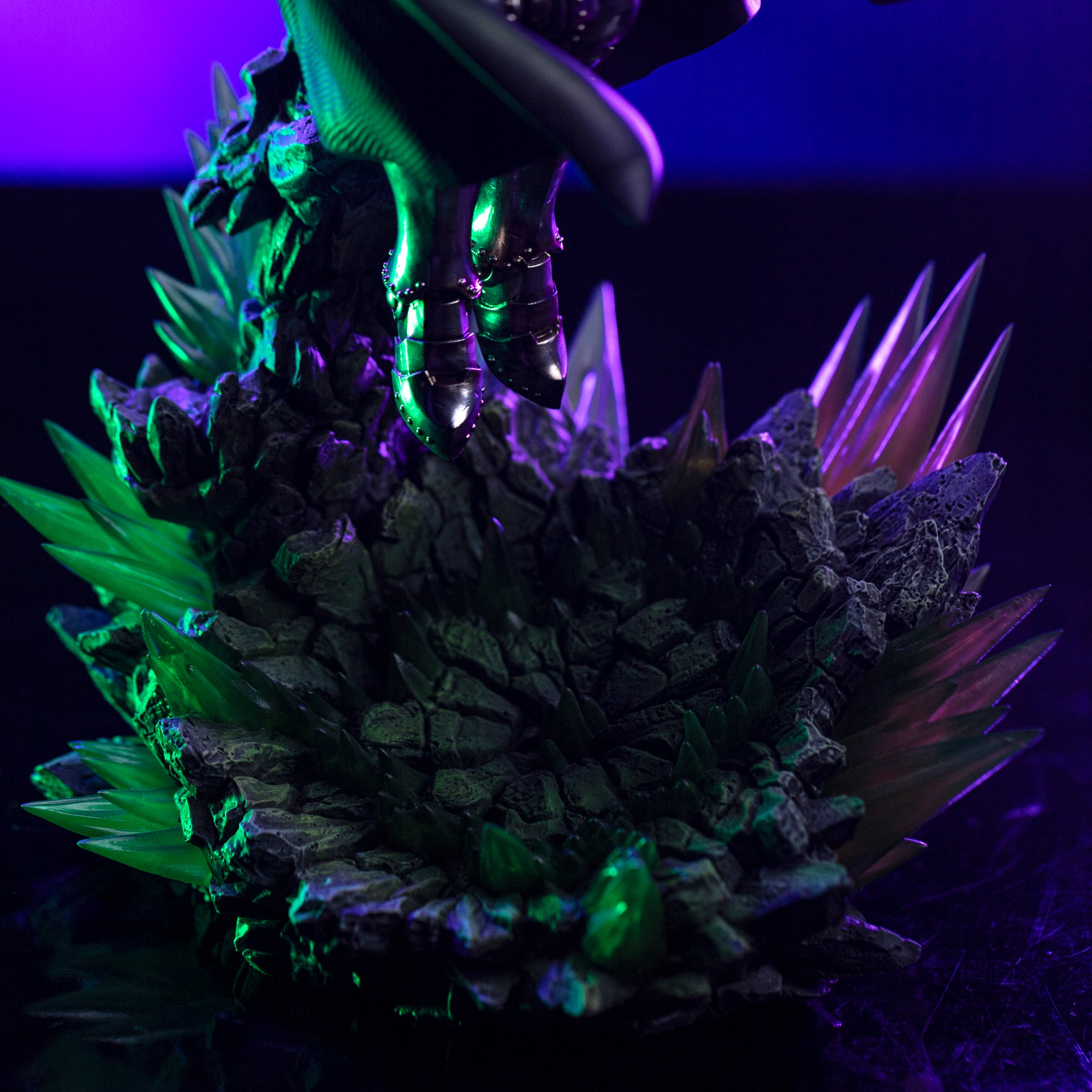 A detailed close-up of the Infinity Gauntlet diorama base, showing the contrast between the rough rock and the jagged, glowing green crystals.