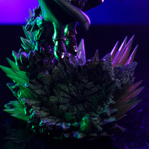 A detailed close-up of the Infinity Gauntlet diorama base, showing the contrast between the rough rock and the jagged, glowing green crystals.