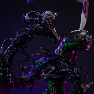 Close-up detail of the symbiotic tendril on the base, showing its menacing open mouth, sharp teeth, and black, glossy texture.