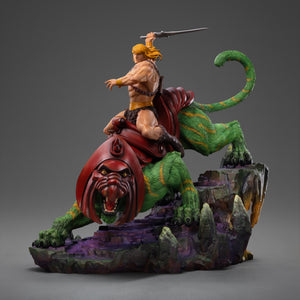 Side profile view of the Iron Studios 1/10 scale He-Man and Battle Cat statue on a rocky Eternia base, isolated on a solid grey background.