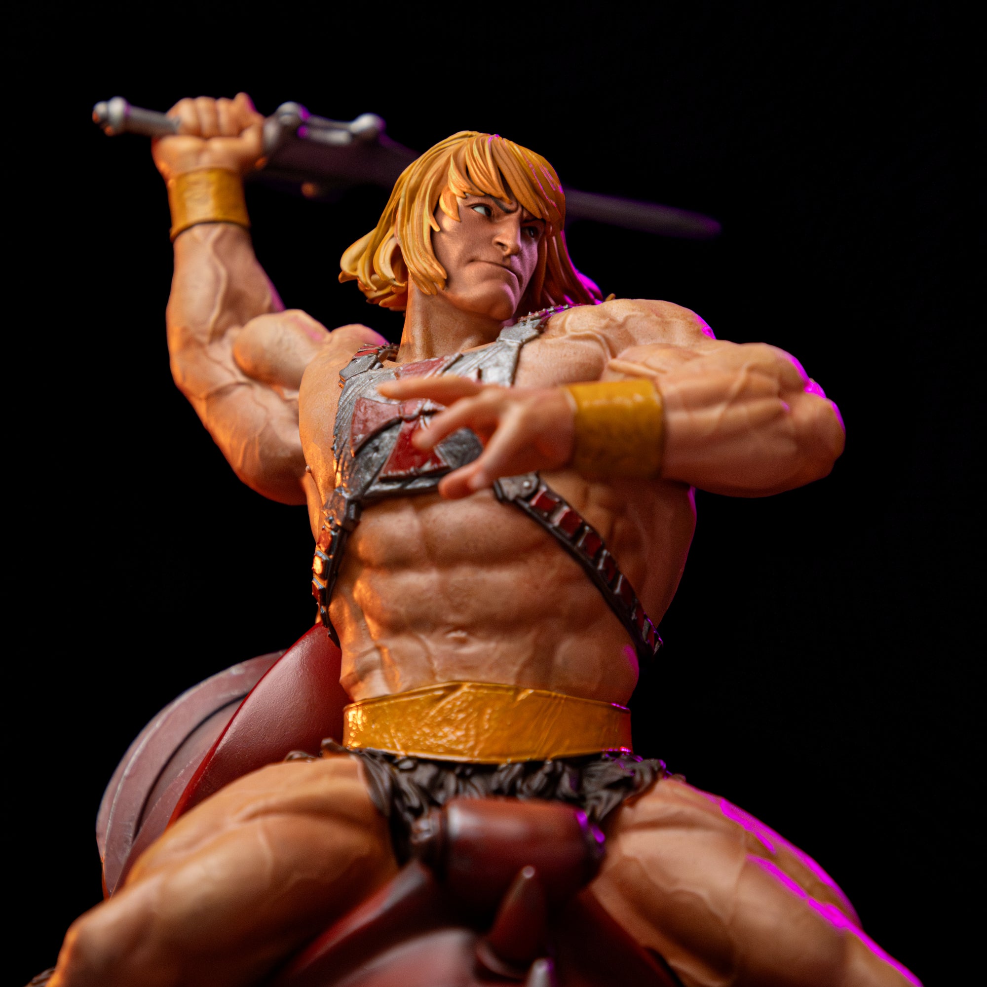 Close-up front view of He-Man's torso on the deluxe 1/10 scale statue, focusing on his iconic red and silver chest harness and battle-ready pose.