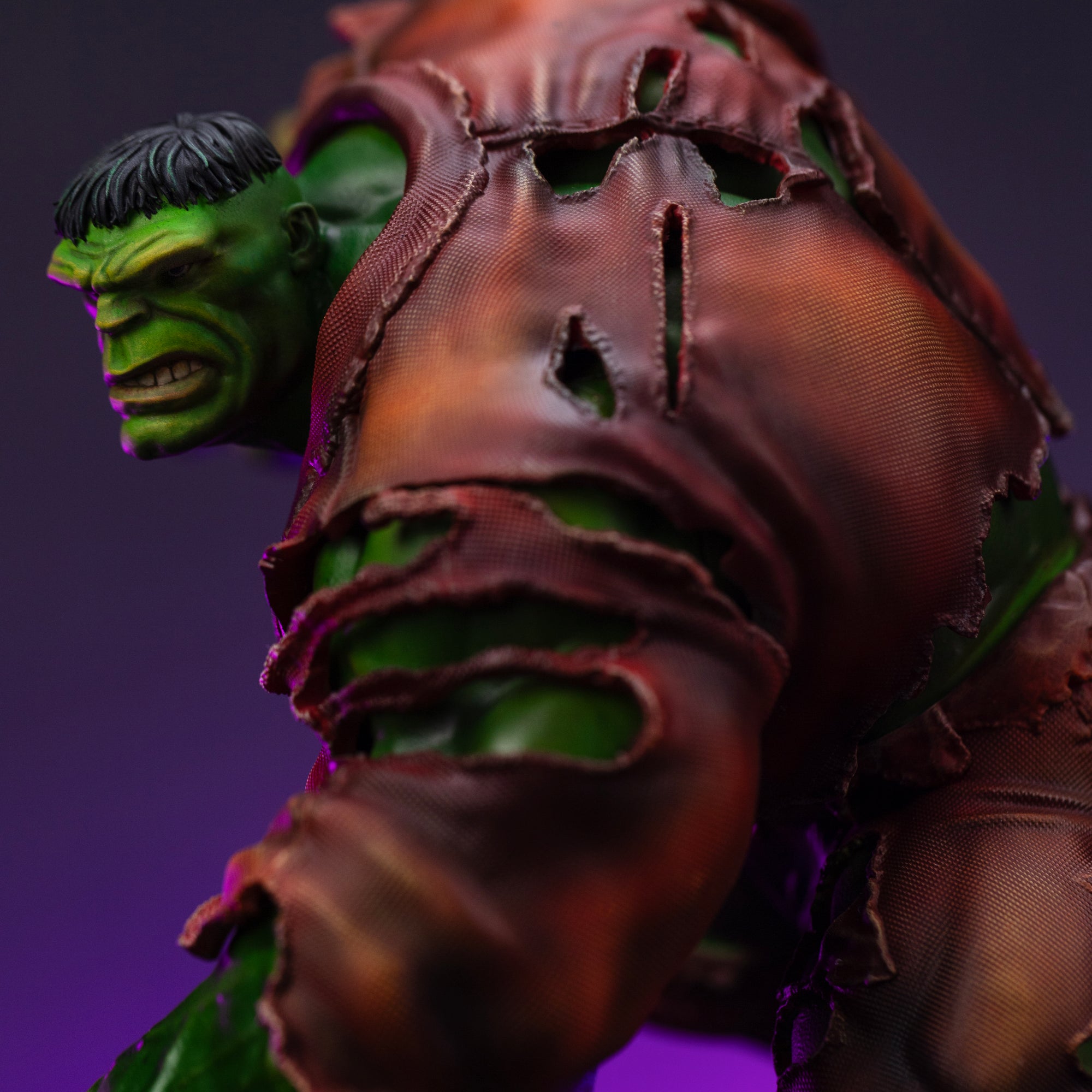 A close-up of Hulk's shoulder and face, showing the rips in his brown clothing and his angry profile.