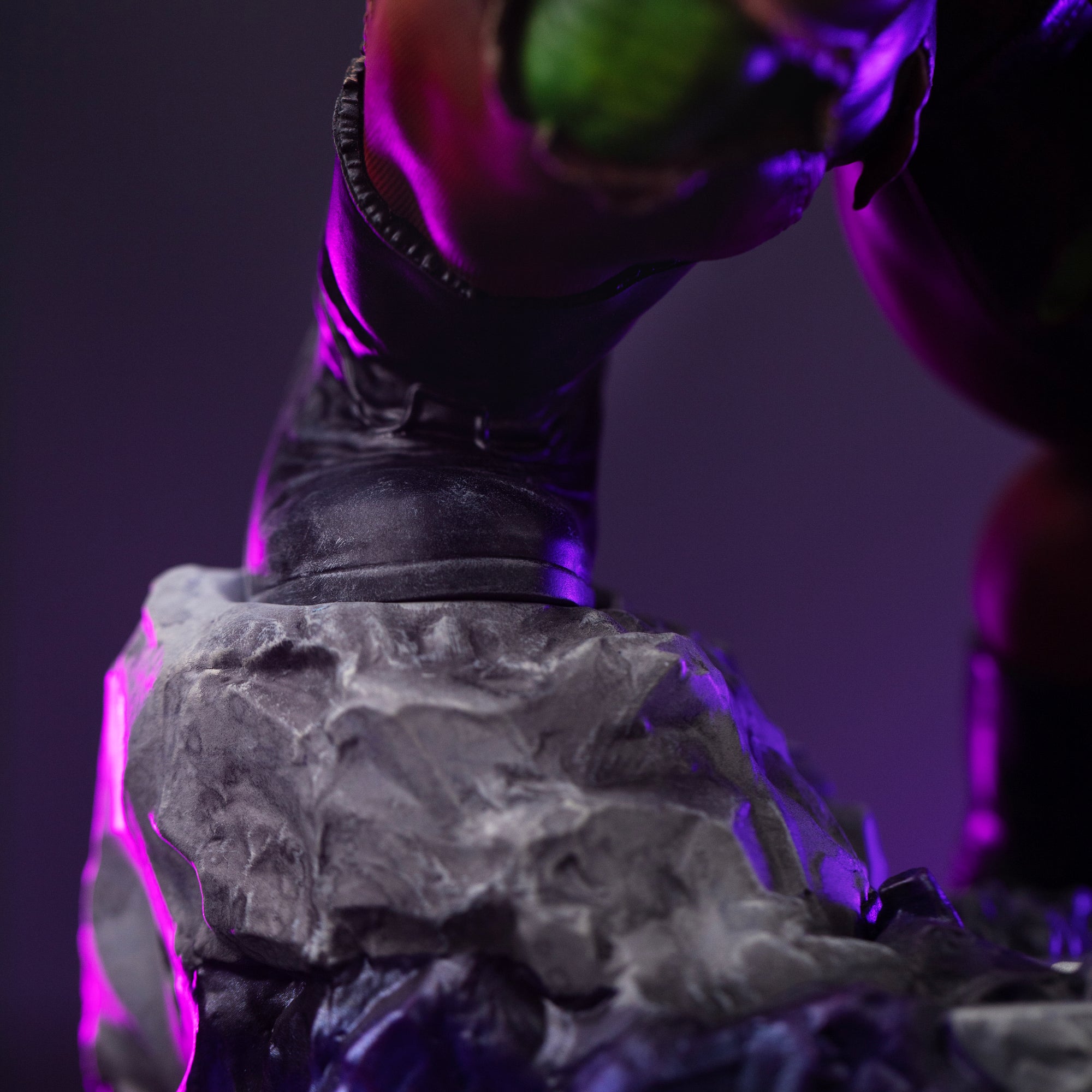 A focused close-up on Hulk's boot resting on a large piece of sculpted rock on the diorama base.