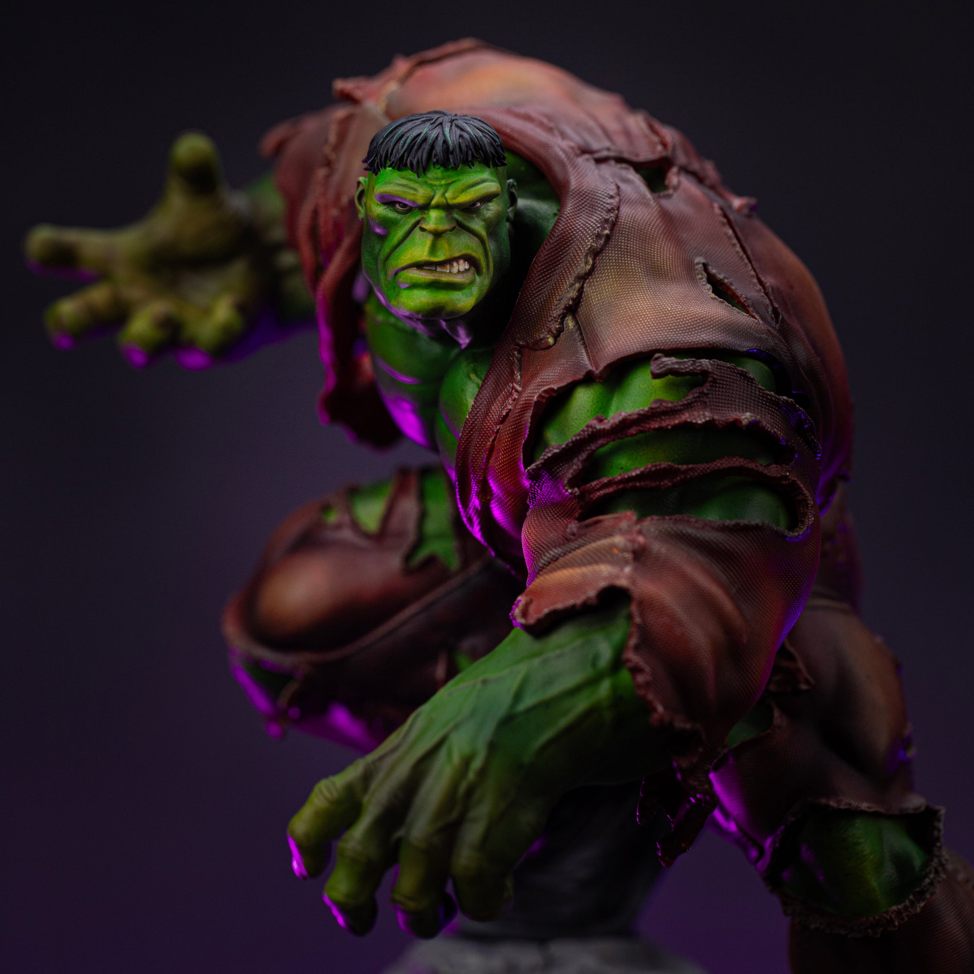A close-up of the Hulk Deluxe statue's face, showing his fierce, aggressive expression and his massive hand reaching out.
