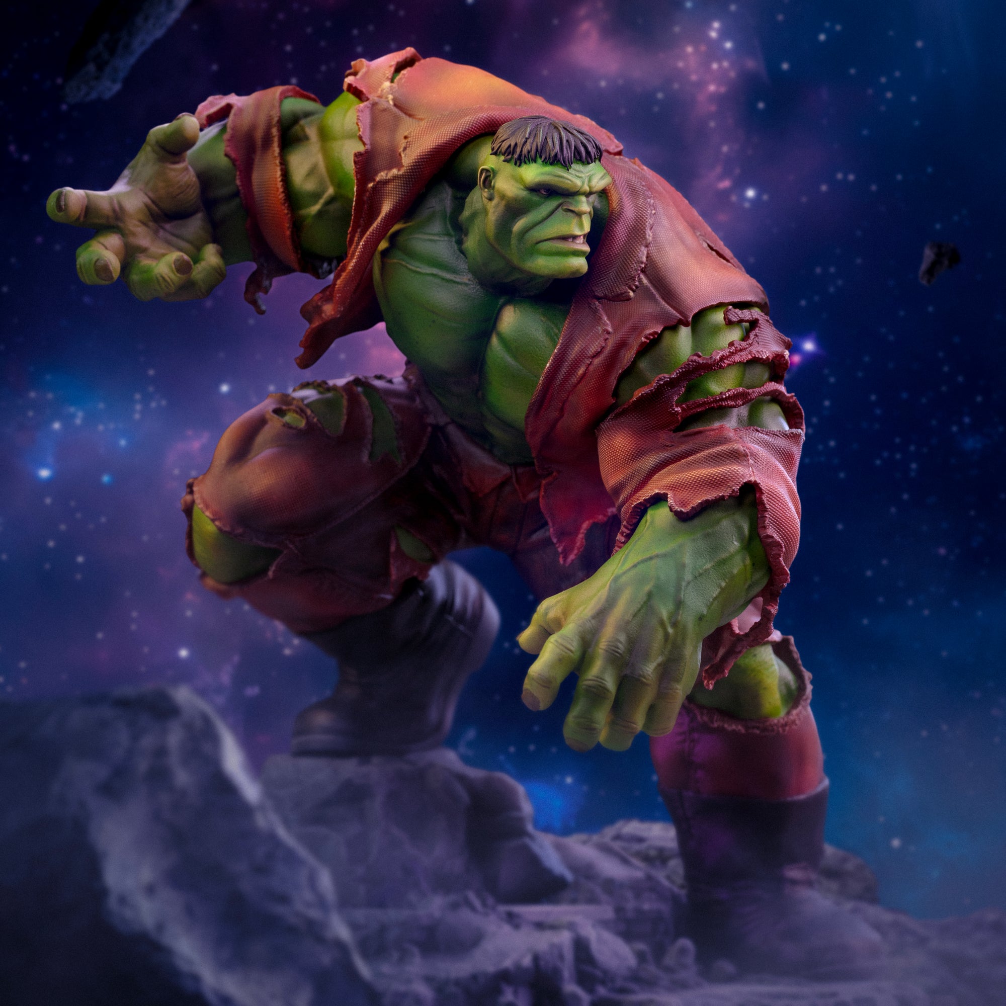 A dynamic action close-up of the Hulk Deluxe statue, highlighting his powerful pose and aggressive expression against a cosmic background.