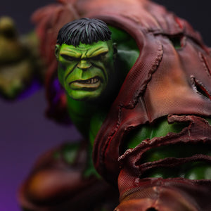 An extreme close-up of the Hulk statue's face, highlighting his furrowed brow, aggressive expression, and short black hair.