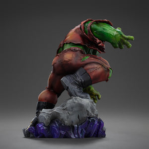 Rear view of the Hulk statue, showcasing the texture of his torn pants, back muscles, and the rocky base with purple energy effects.