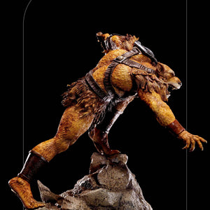 A clean right profile of the Jackalman statue, showing the full figure and its pose on the rocky base against a black background.
