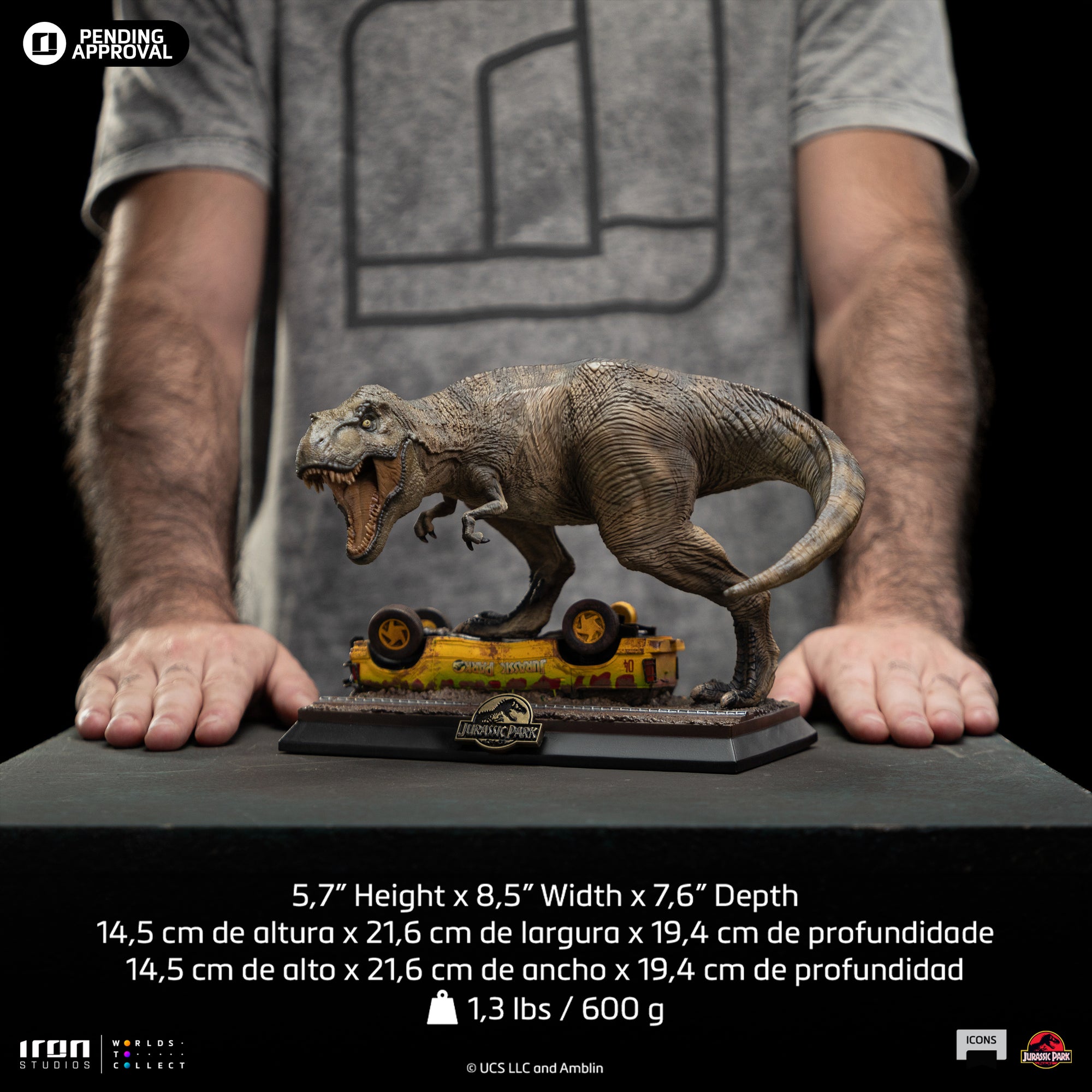 Front product view of the Iron Studios Icons series Jurassic Park T-Rex Attack 1/10 scale statue, held by a person to show scale, including text overlaid with dimensions 5.7 by 8.5 by 7.6 inches.