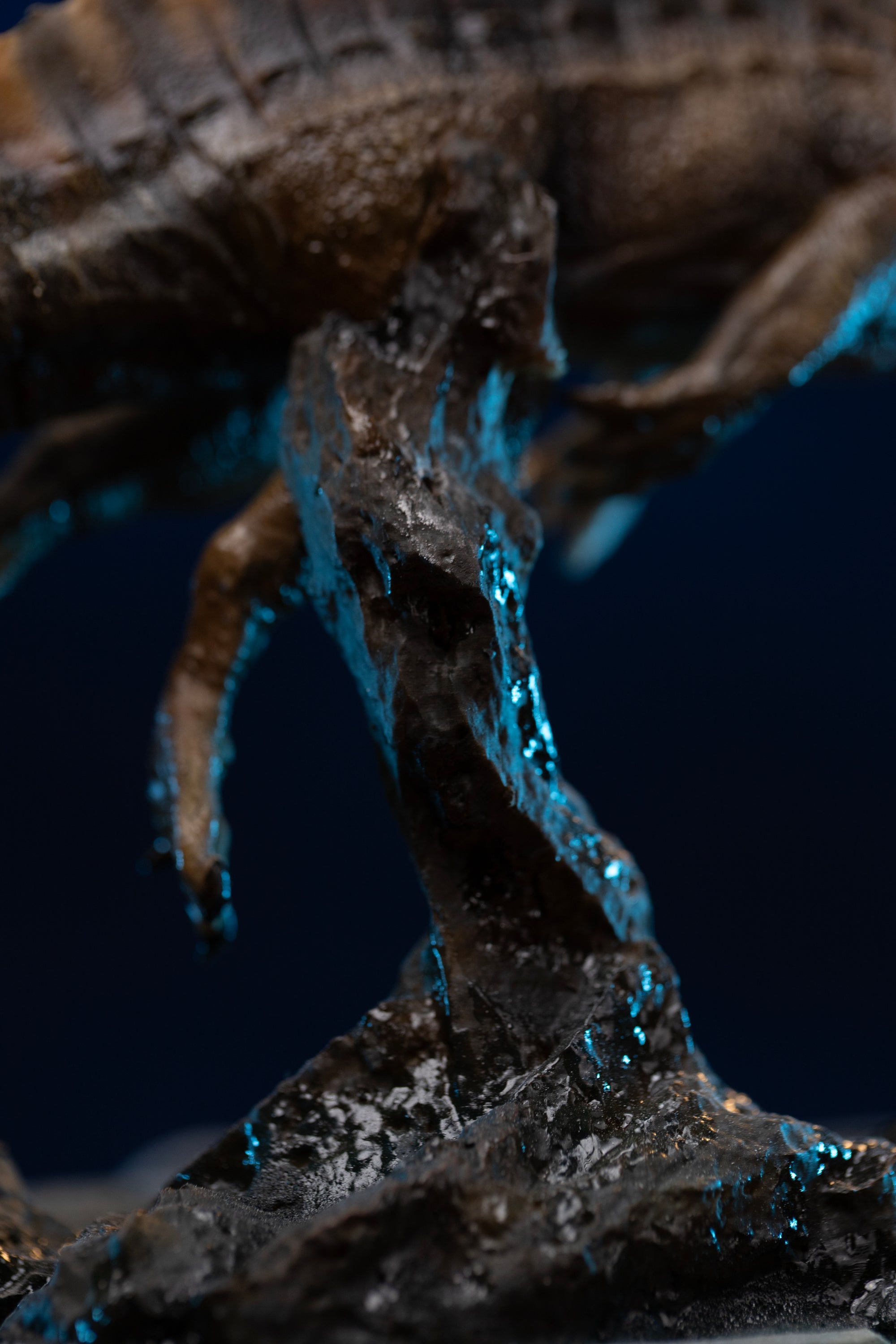 Detail view of Iron Studios Spinosaurus statue rock pillar base mount and splash effects