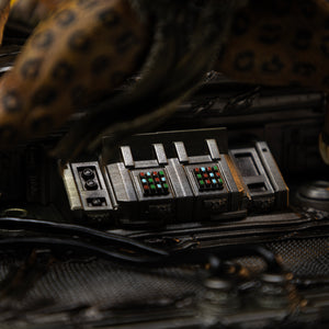 A detailed close-up of the industrial elements on the Kraven diorama base, including wires and control panels.