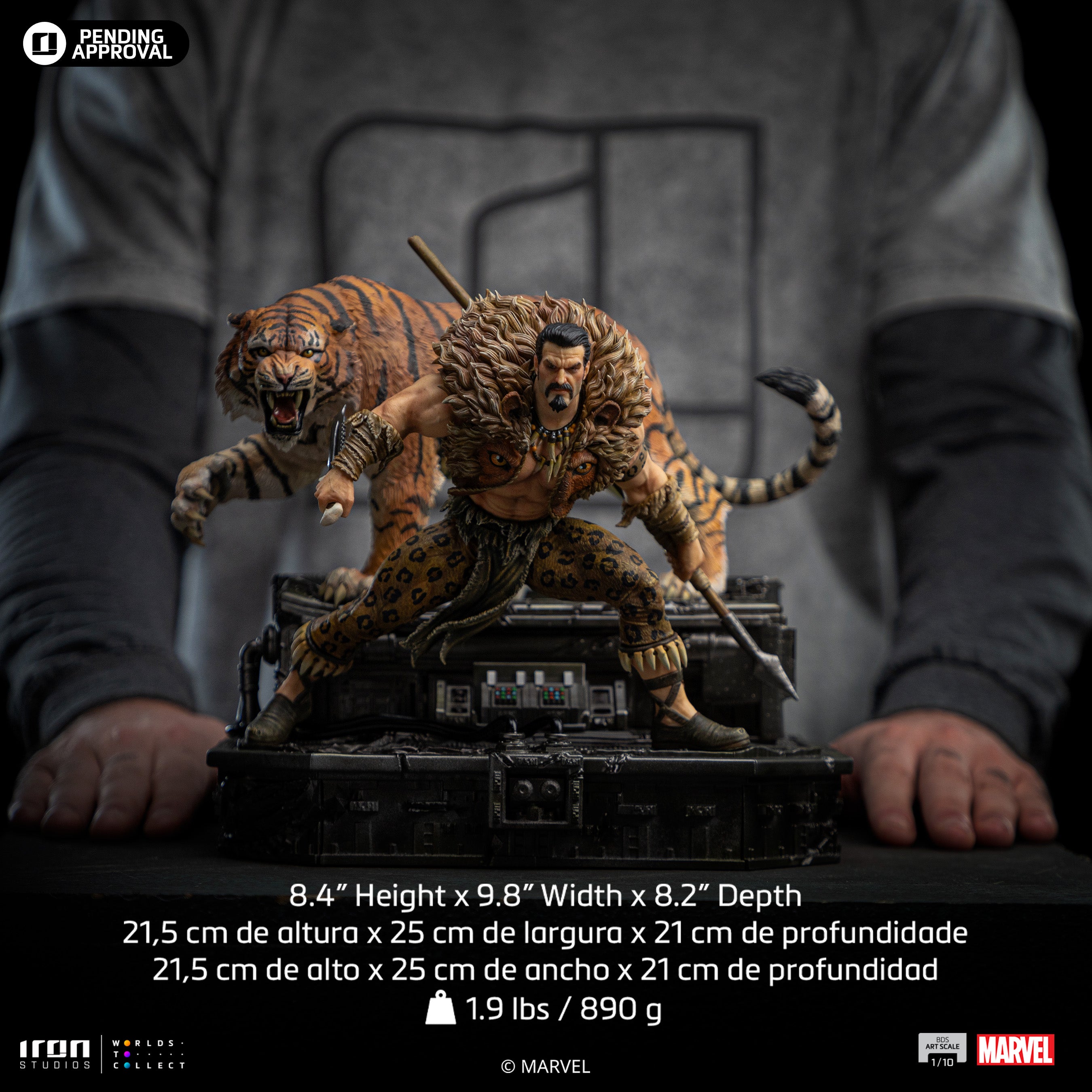 A size comparison photo of the Iron Studios Kraven the Hunter statue held by hands, with its height of 8.4", width of 9.8" and depth of 8.2" listed.
