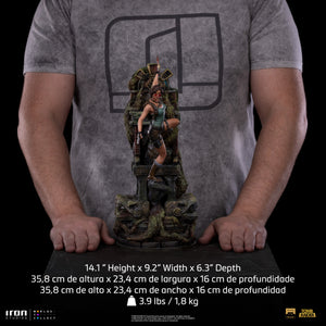 A size comparison photo of the Iron Studios Lara Croft Deluxe 1/10 scale statue, showing its 14.1-inch height with a person's hands for scale.