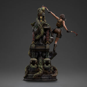 A back view of the Lara Croft statue, showing her in the climbing pose with her backpack and dual climbing axes.