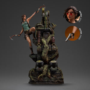 The Lara Croft Deluxe Art Scale 1/10 statue shown with callouts for the interchangeable head (no sunglasses) and hand (pistol) accessories.