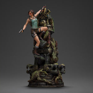An angled front view of the Lara Croft statue with sunglasses and pistol, highlighting the detailed jungle ruins base.