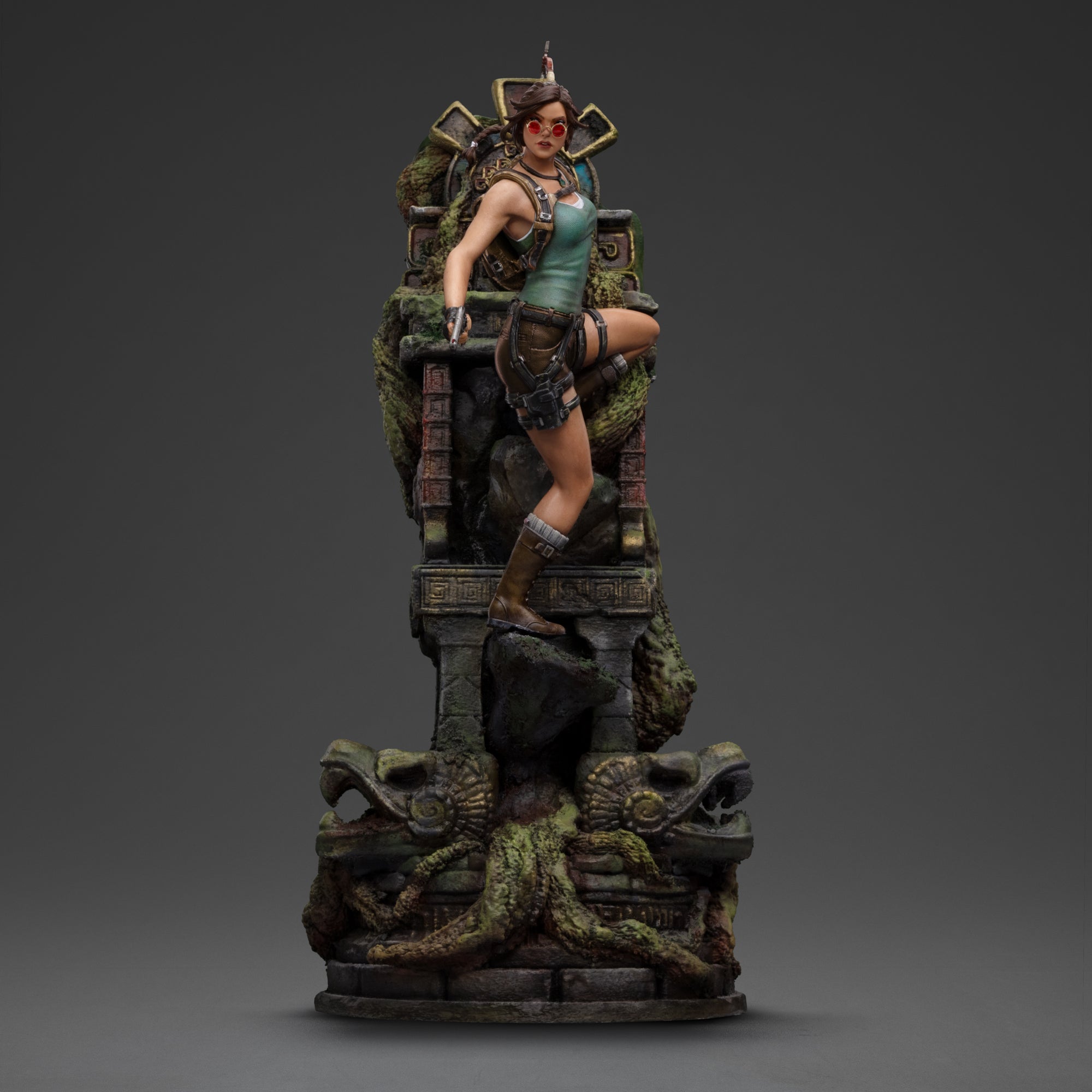Front view of the Iron Studios Lara Croft 1/10 scale statue, showing her with red sunglasses and pistol, climbing the ancient jungle ruin base.