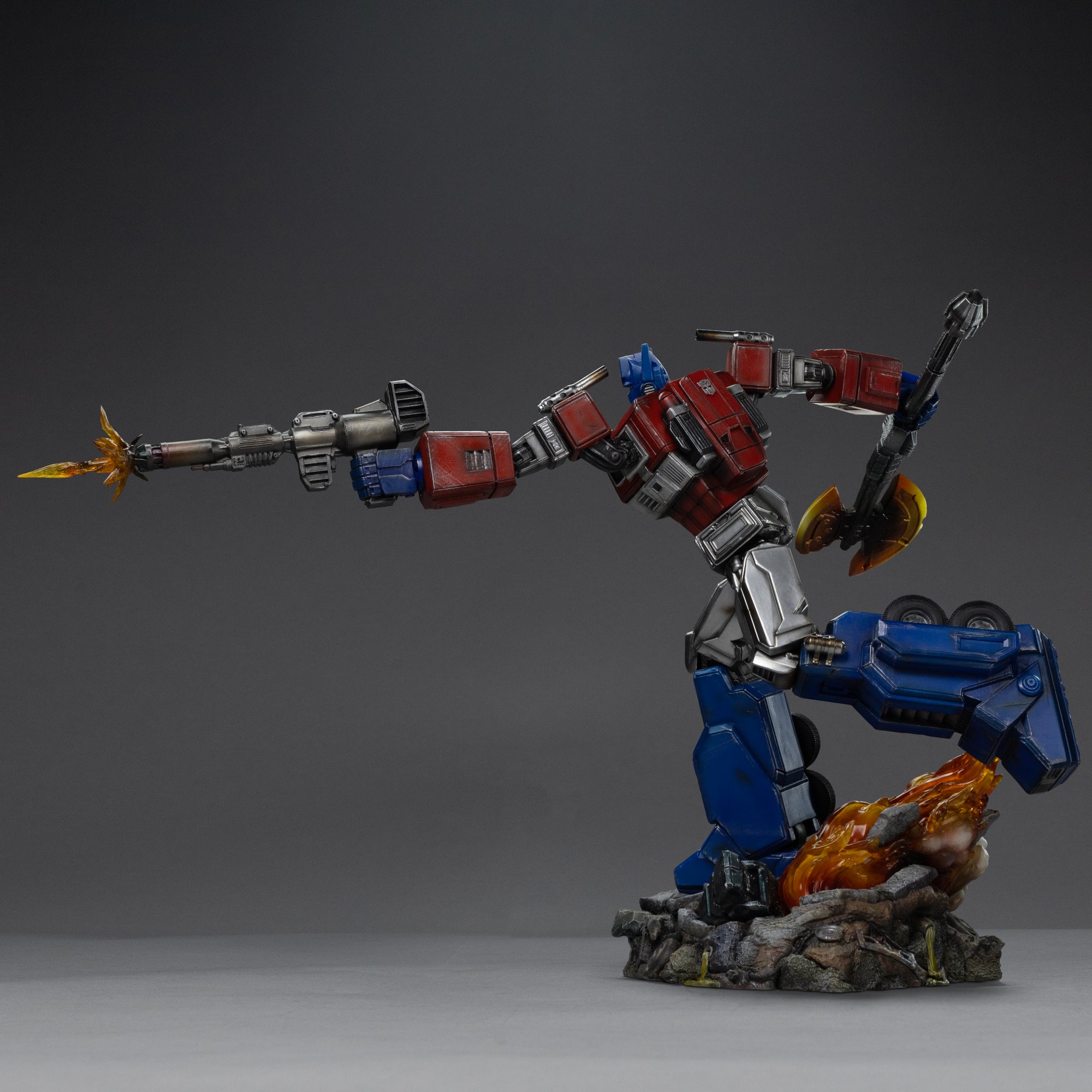 Side profile view of the Iron Studios 1/20 scale Optimus Prime statue aiming an ion blaster with blast effect.