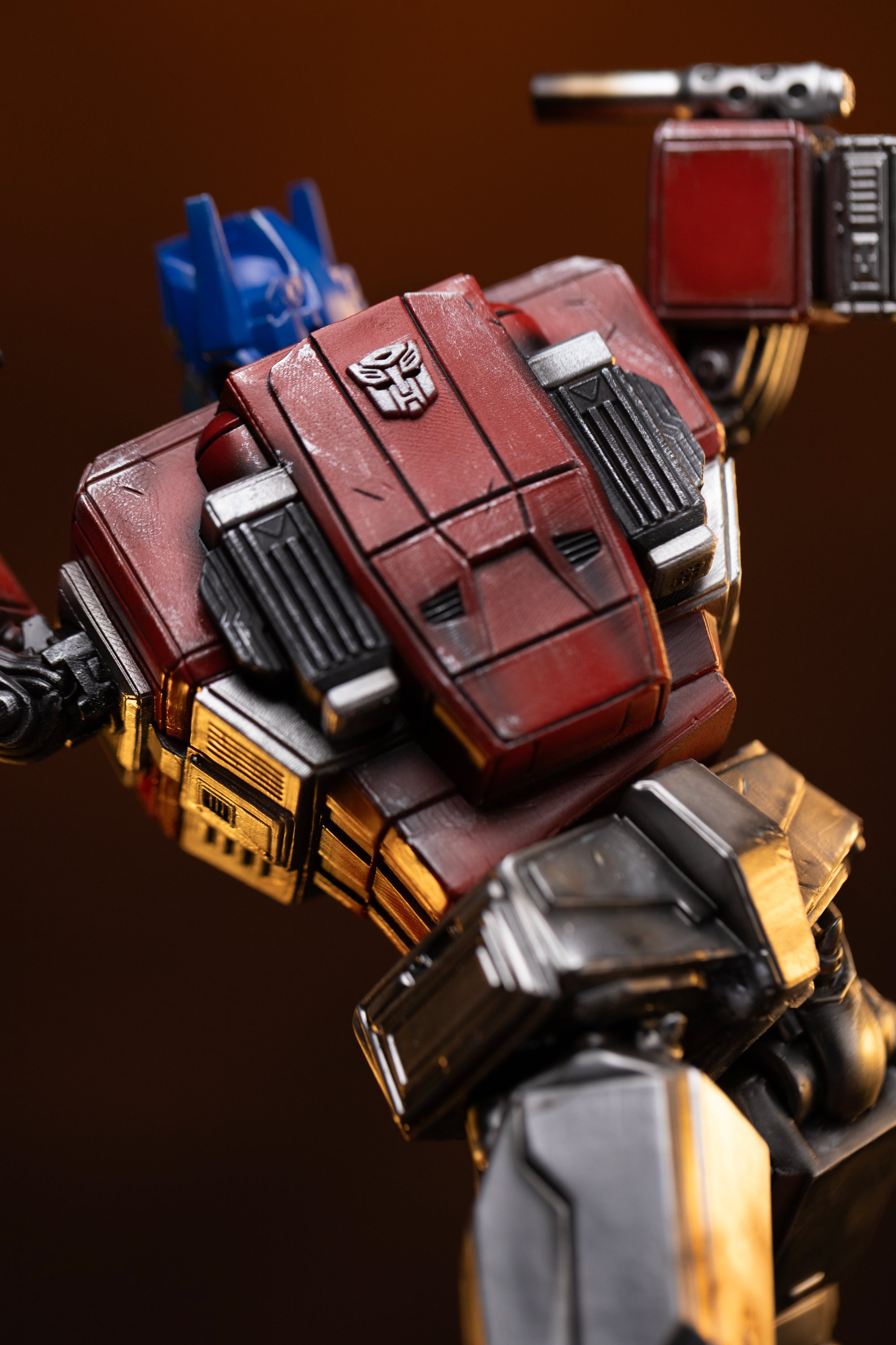 High-angle close-up of the upper back panel and embossed Autobot insignia on the Iron Studios Optimus Prime statue.