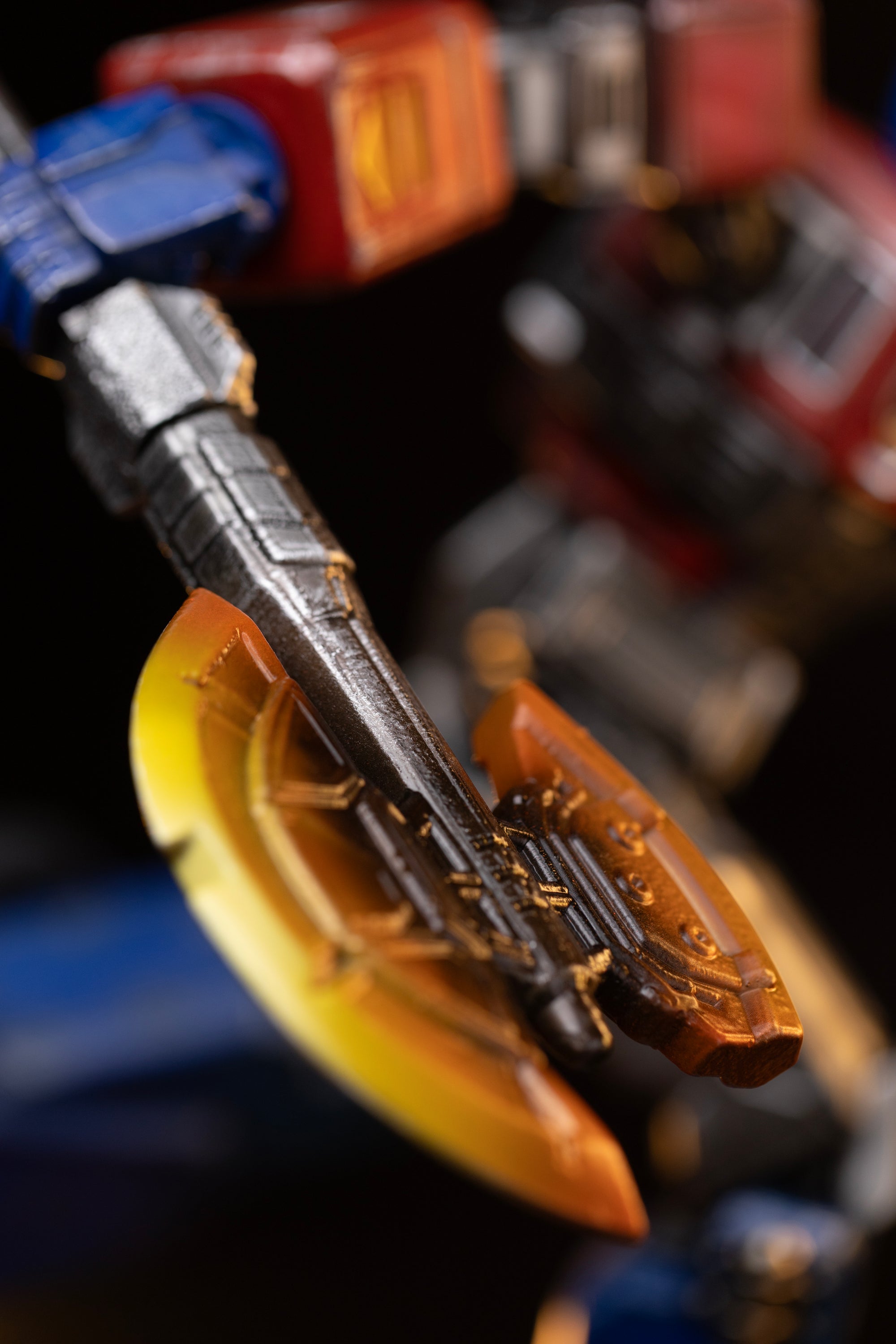 Detailed close-up of the translucent glowing orange and yellow Energon axe weapon wielded by Optimus Prime.