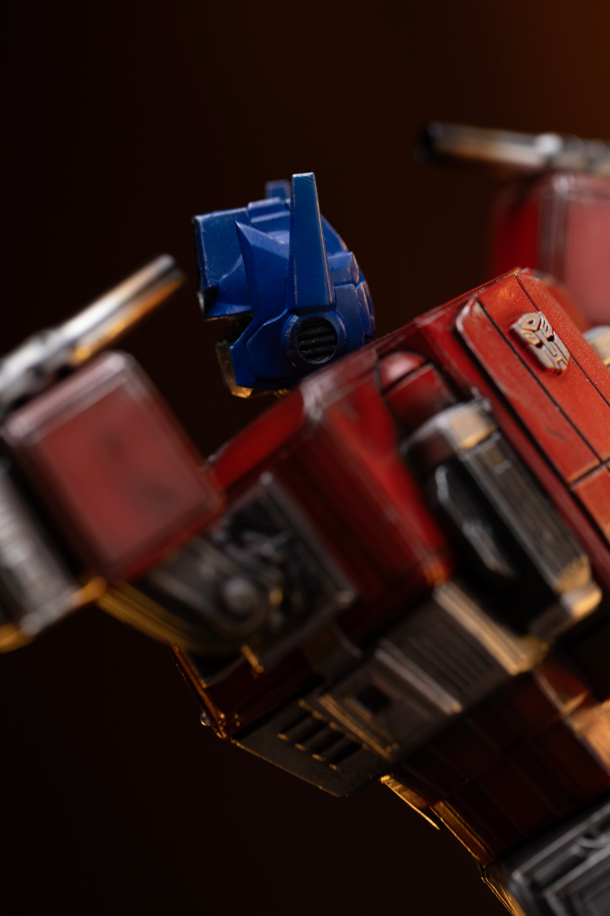 Side view showing the detailed sculpt of Optimus Prime's ear antenna, helmet paneling, and chrome exhaust smokestack.