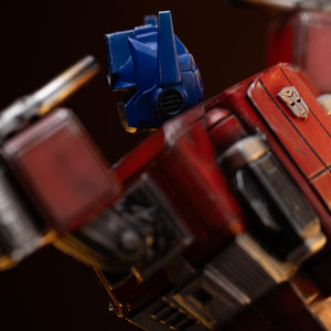 Side view showing the detailed sculpt of Optimus Prime's ear antenna, helmet paneling, and chrome exhaust smokestack.