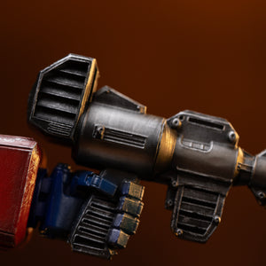 Close-up of the weathered black Ion Blaster rifle gripped in Optimus Prime's hand on the Iron Studios statue.