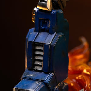 Detailed close-up of the weathered blue leg armor, foot hydraulics, and rubble base of the Optimus Prime Iron Studios statue.