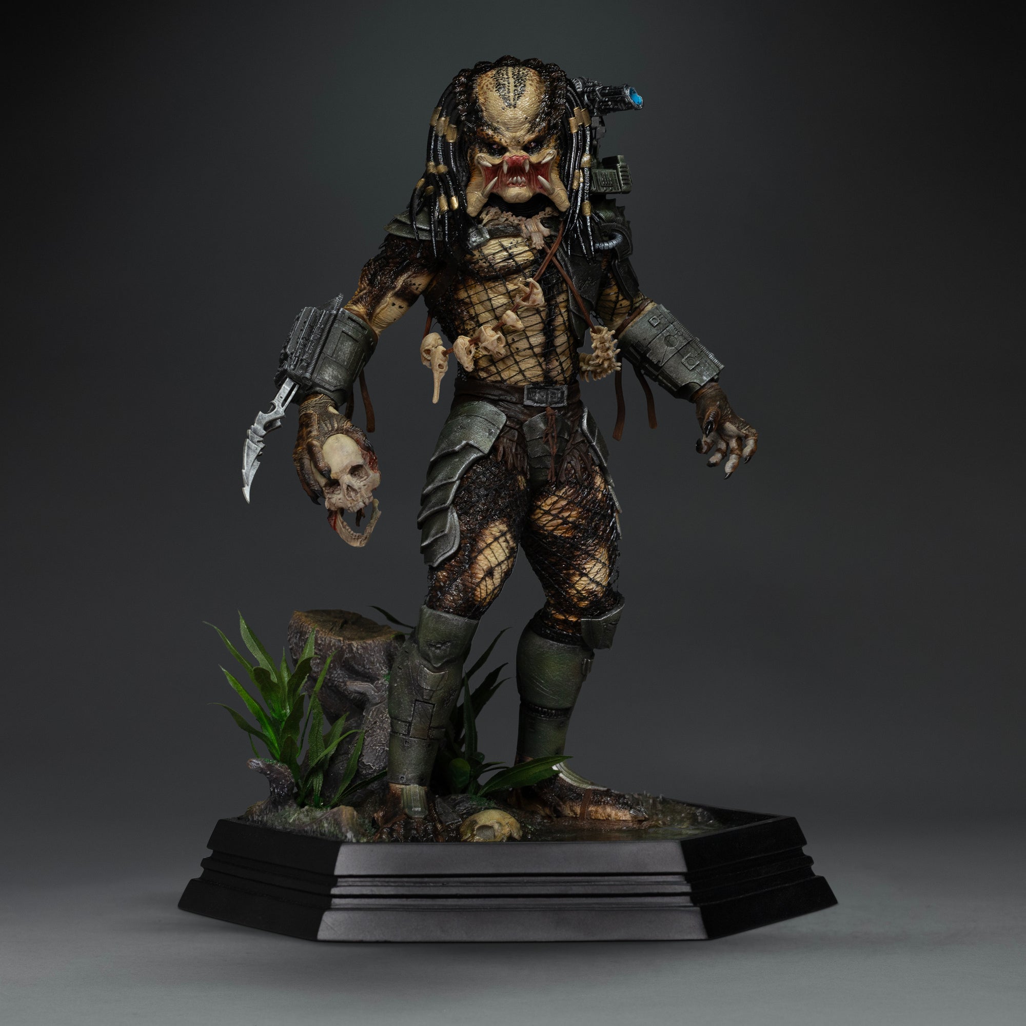 Front view of Iron Studios 1/10 Predator Jungle Hunter unmasked statue holding severed skull accessory