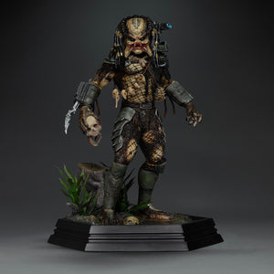 Front view of Iron Studios 1/10 Predator Jungle Hunter unmasked statue holding severed skull accessory