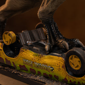 Extreme close-up shot focusing on the hand-painted textured dinosaur claws of the Iron Studios T-Rex statue crushing the rusted undercarriage of the tour vehicle.