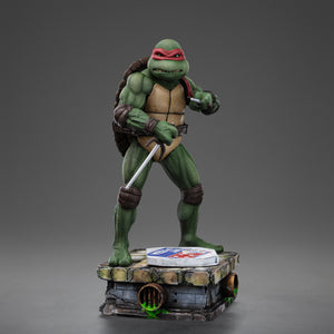 Full front view of the Iron Studios TMNT 1990 Raphael 1/10 scale statue in a defensive stance on a sewer diorama base with pizza box.
