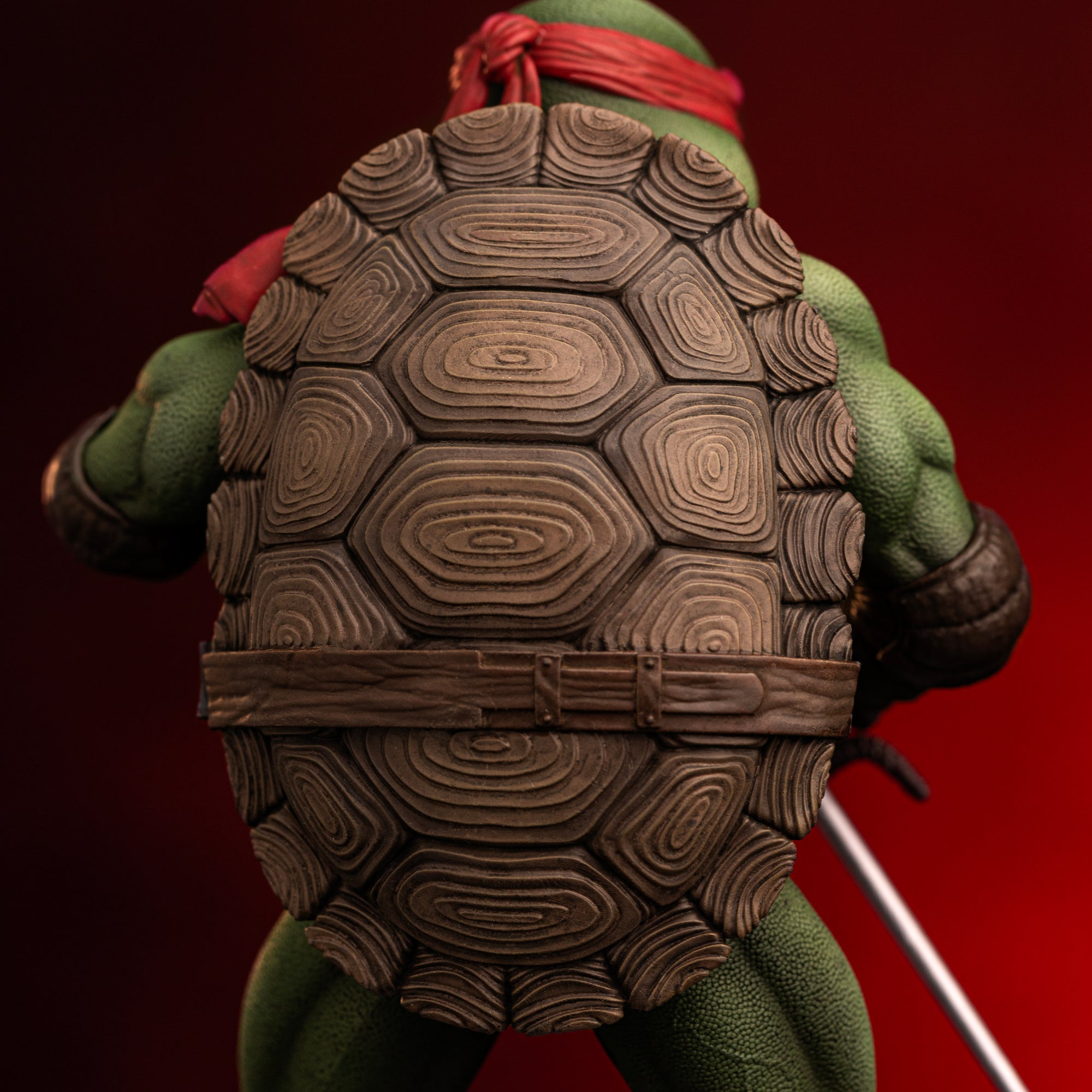 Rear view close-up showing the grooved brown carapace shell and utility belt sculpt on the Iron Studios TMNT 1990 Raphael statue.