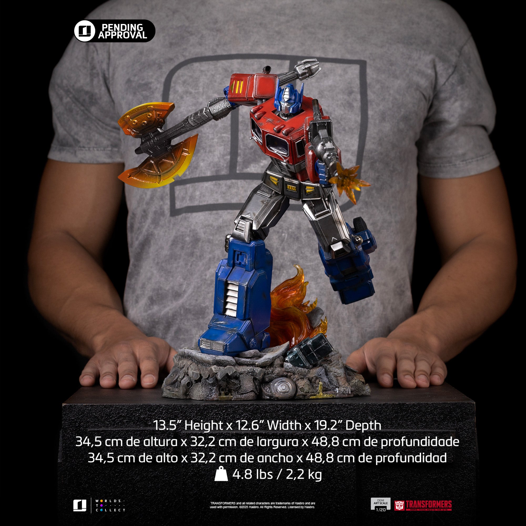 Dimensions and scale reference for the Iron Studios Transformers Optimus Prime 1/20 Demi Art Scale statue held by a collector.