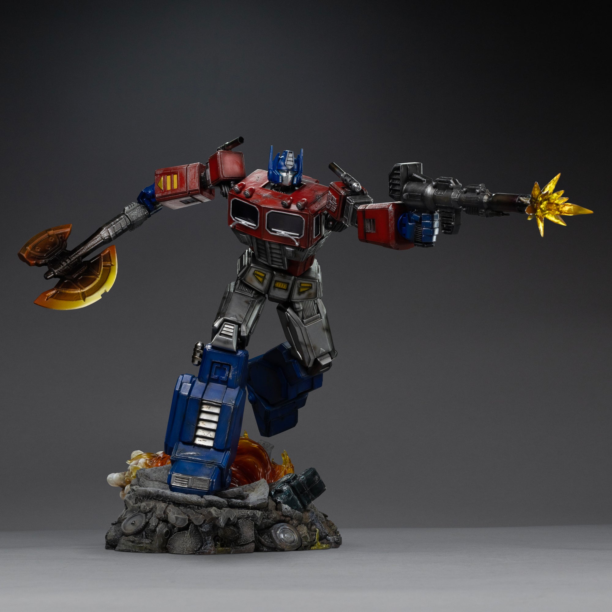 Low-angle perspective of the Iron Studios Optimus Prime 1/20 polystone statue advancing over a battle-damaged diorama base.
