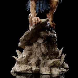 A detailed close-up of the base of the Vultureman statue, showing his clawed hand and foot gripping the textured rock.